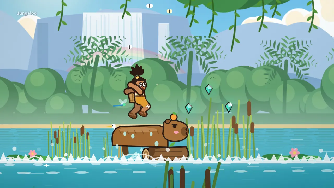 Ribbon River on a sunny day: Dumpling, a big brown capybara with pink cheeks and an orange balanced on his head, hops up over a floating log in white foamy water, and Tavo, tossed off his back, flies above him with his knees tucked; teal gems float over the reeds on the right, cattails and pink water lilies line the river, a heron peeks out from behind Dumpling, and a tall waterfall with a faint rainbow stands far behind the green trees